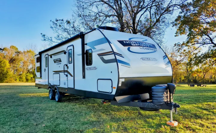 Northern Spirit Ultra Lite travel trailer rv rental, parked in a sunny grassy field ready for adventure.. Coachmen Northern Spirit 2024