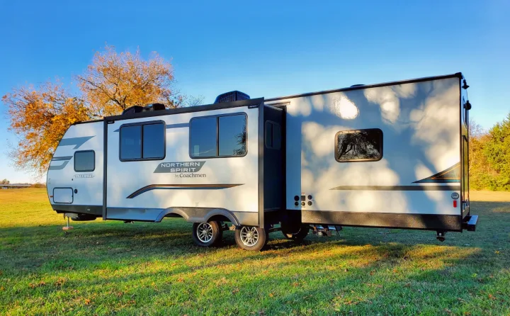 A spacious Coachmen Northern Spirit travel trailer, perfect for an RV rental adventure, parked in a sunny field.. Coachmen Northern Spirit 2024