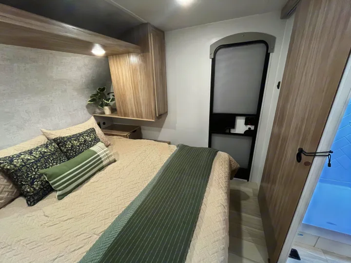 Experience comfort in this modern RV rental bedroom. Features a queen bed, overhead storage, and a stylish, compact interior.. Winnebago Access 26 RL 2024