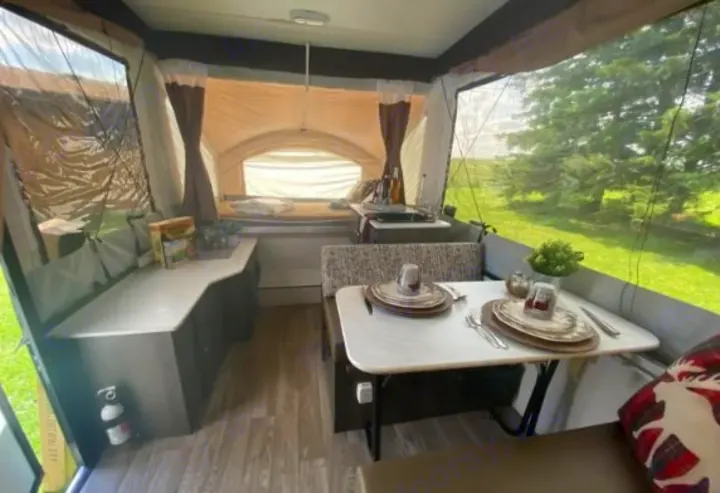 Explore this pop-up RV rental: interior with comfy dining, kitchen, and bed, offering scenic outdoor views. Your next travel adventure!. Coachmen epic 1906 2019