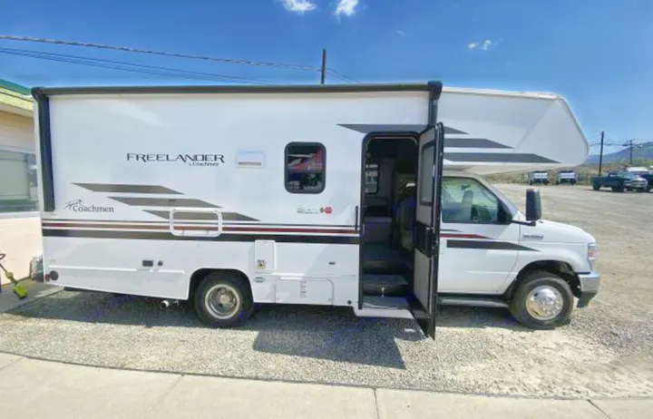 White Coachmen Freelander Class C RV for rv rental, parked outdoors with the entrance door open.. COACHMEN FREELANDER 21RS 2023