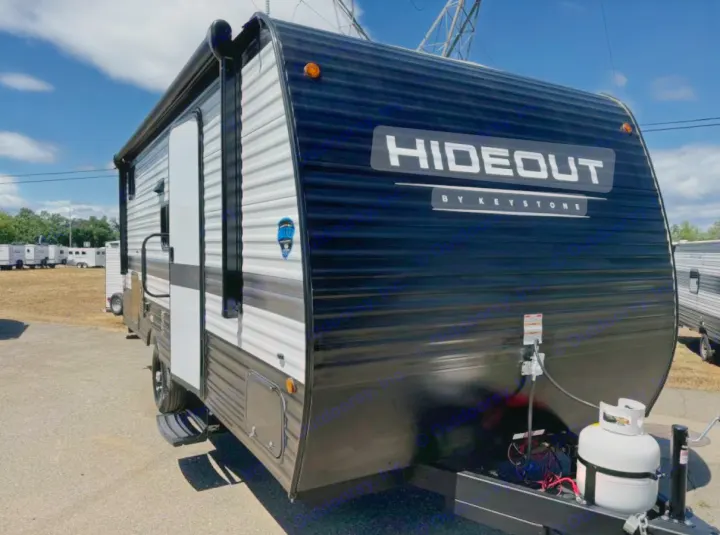 Modern black & white Keystone Hideout travel trailer, ideal for an RV rental. Features front propane tank & side entry door.. Keystone RV Hideout Sport 2024