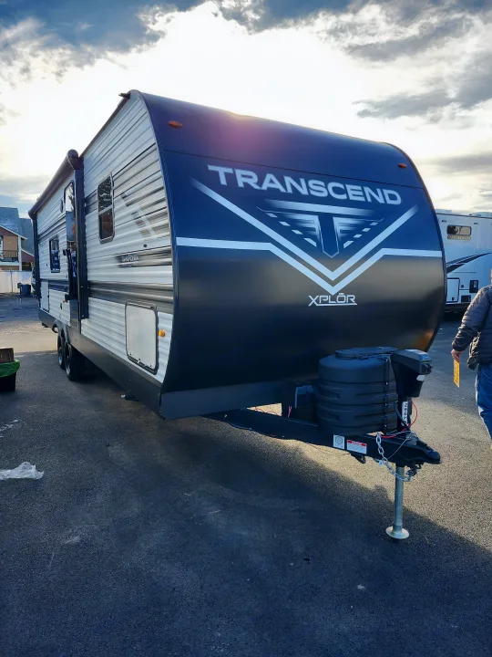 Daylight illuminates this Transcend Xplor travel trailer, parked outdoors and available for RV rental.. Grand Design Transcend 2025