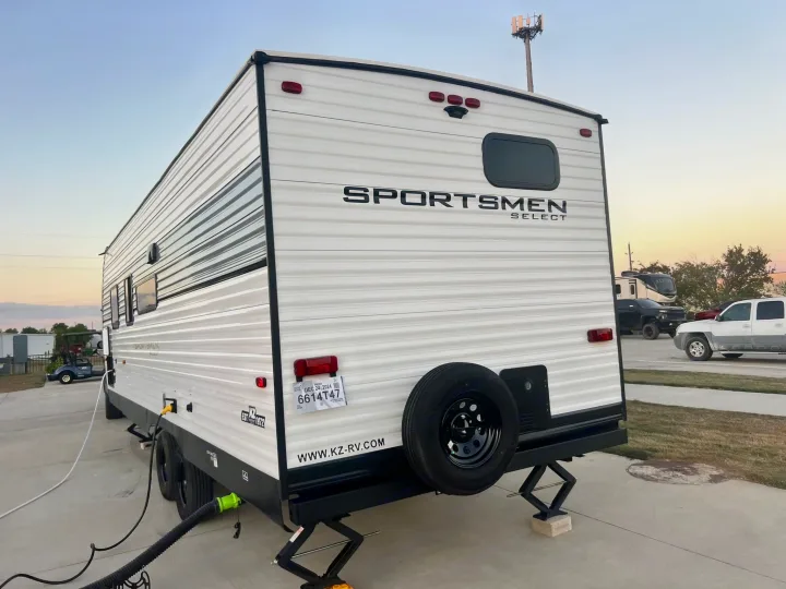 This RV rental, a white Sportsmen Select travel trailer, is fully set up with utilities. Perfect for a mobile home experience!. Other Other 2024