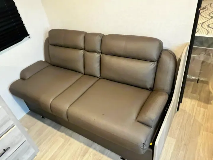 RV rental: Modern grey faux leather reclining sofa, offering comfortable seating inside an RV.. Other Other 2024