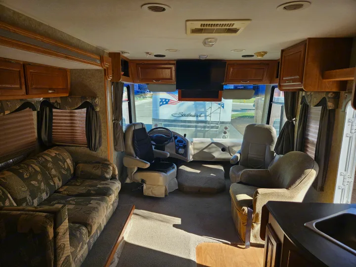 Explore this RV rental's spacious interior: living area with sofa, kitchen counter, and front driving seats.. Coachmen Mirada 2007
