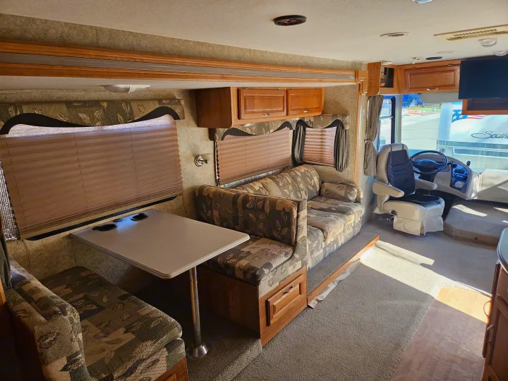Spacious RV rental interior with dinette, sofa, and cockpit view. Perfect for your next adventure!. Coachmen Mirada 2007