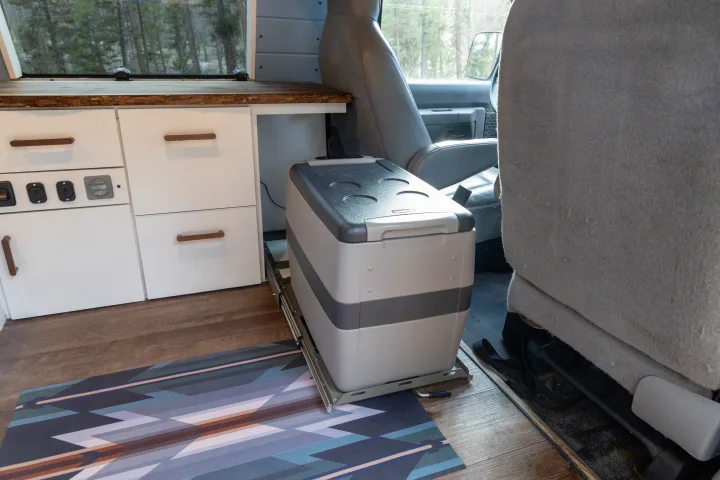 This RV rental's interior features a pull-out refrigerator, custom cabinetry, and wooden floors for comfortable travel.. Ford Econoline 150 2009