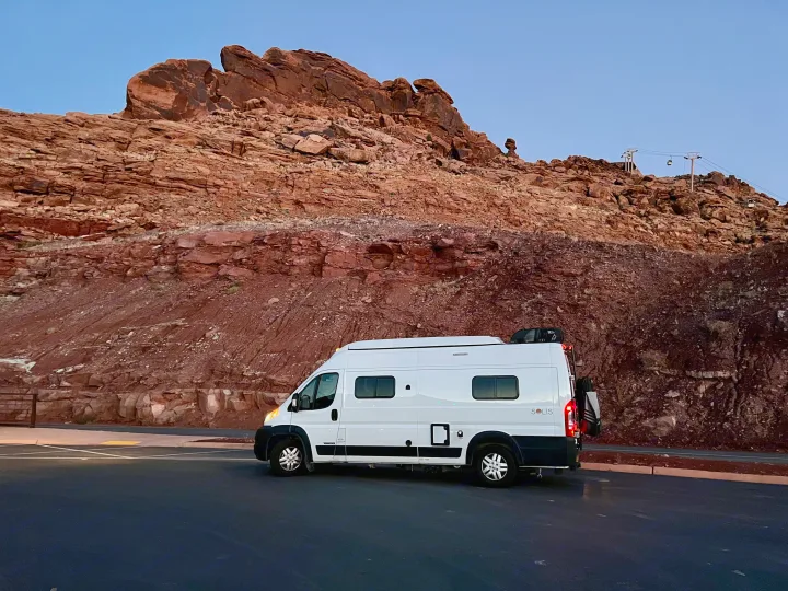 Experience travel freedom with an RV rental: White camper van beside stunning red rock mountains and a cable car.. Winnebago Winnebago 2023