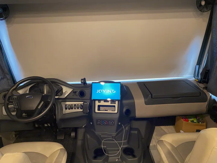 RV rental cockpit view, showcasing the modern dashboard, Ford steering wheel, and front seats, ready for adventure.. Coachmen Encore 2022