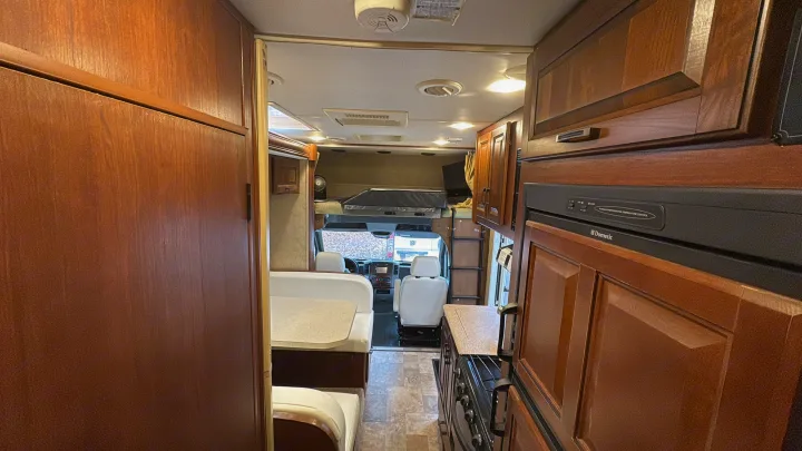 Inside this RV rental: motorhome interior featuring a galley, dinette seating, and driver's cockpit. Perfect for road trips.. Forest River Solera 24R 2014