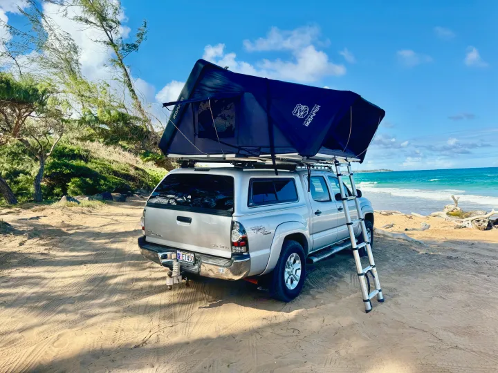Explore the coast! An RV rental, a pickup with an iKamper roof-top tent, parked for beach camping by the beautiful ocean.. Toyota Tacoma 2010