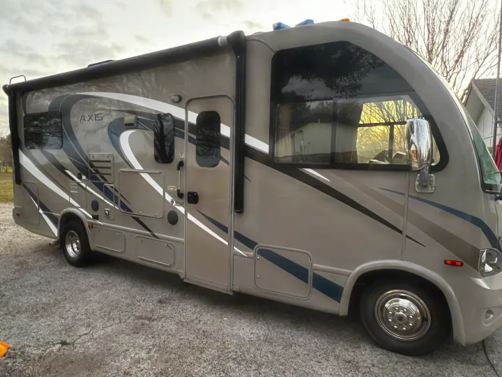 This modern Thor Axis RV rental is ready for your next road trip adventure, parked on asphalt under an overcast sky.. Thor Axis 2016