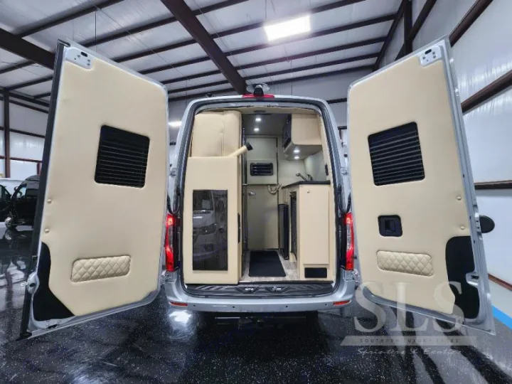 Explore this luxury RV rental! Custom camper van interior with a kitchenette and cozy setup for travel.. Ultimate Toys Ultimate Cruiser 2023