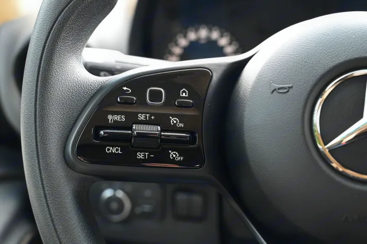 RV rental steering wheel detail: Cruise control buttons (SET+, SET-, RES, CNCL) and multimedia controls are clearly visible.. Ultimate Toys Ultimate Cruiser 2023