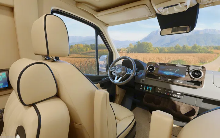 High-end RV rental interior: cream leather seating, a Mercedes dashboard with PRO display, and a panoramic mountain view.. Ultimate Toys Ultimate Cruiser 2023
