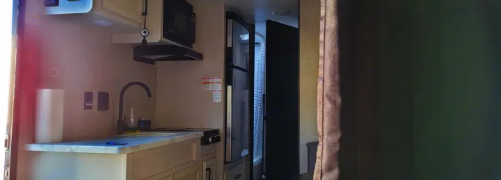 RV rental: Bright, modern kitchen area with sink, microwave, stovetop, and refrigerator. Compact design, practical for travel.. Jayco Jay Flight SLX 2024