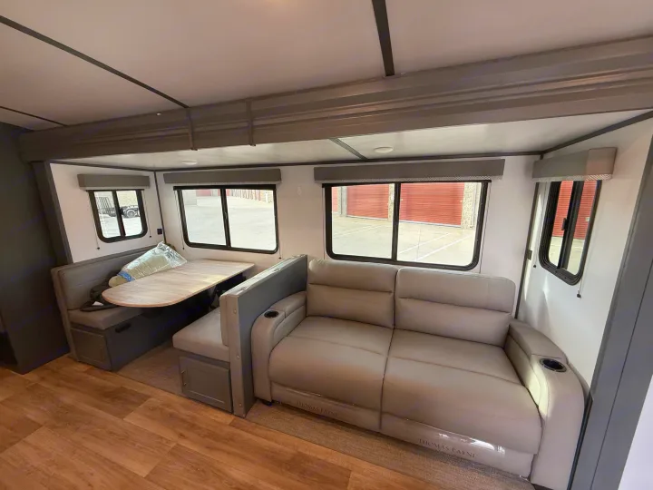 RV rental: Bright interior featuring a dinette, wood-look flooring, and a reclining sofa.. Keystone Bullet 2022