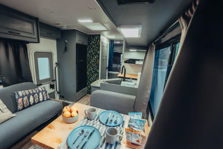 An rv rental's interior: modern dining, kitchen with sink & fridge, and comfy sofa area. Enjoy your mobile home travel.. Four Winds Four Winds Motorhome 2011
