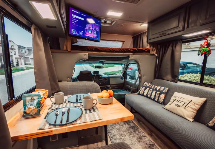 Step inside this cozy RV rental: dining table set for two with snacks, Roku TV, and comfortable seating.. Four Winds Four Winds Motorhome 2011