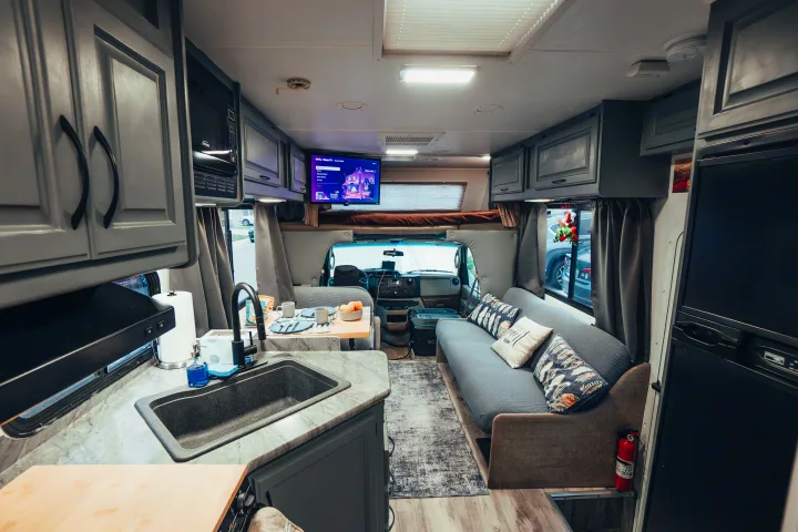 Step inside this modern RV rental: a full kitchen, dining nook, comfy sofa, and overhead bunk are ready for your next adventure.. Four Winds Four Winds Motorhome 2011