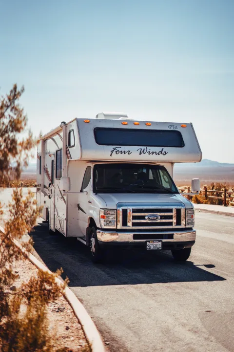 White Four Winds motorhome rv rental parked on a desert road, ready for sunny travel adventures.. Four Winds Four Winds Motorhome 2011