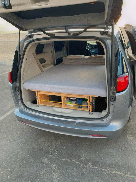 Minivan converted into a camper with a bed and storage, ready for adventure. An ideal RV rental alternative for road trips.. Chrysler Voyager 2022