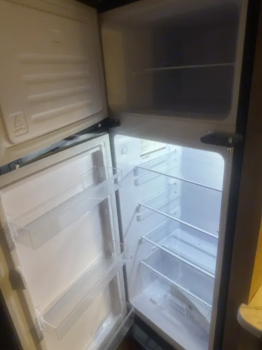 Clean, empty mini-fridge in an RV rental, ready for your trip. Features shelves & door bins.. Forest River Wolf Pup 2025