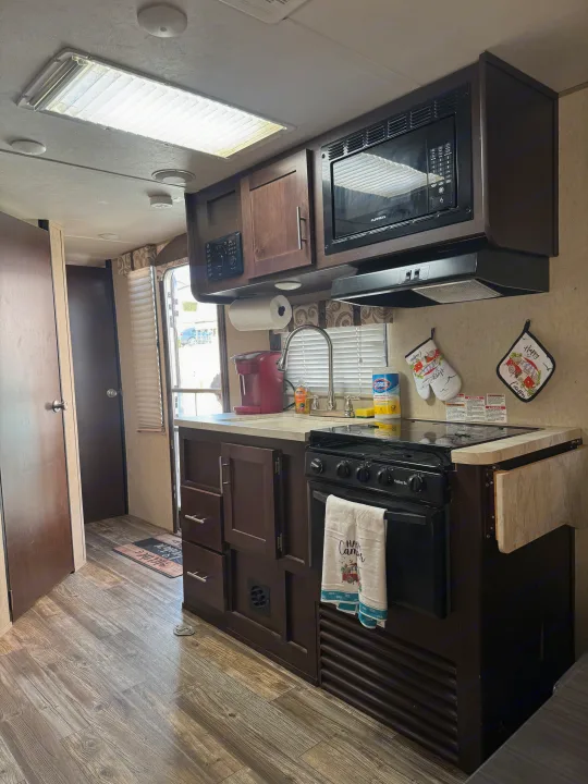 This RV rental's cozy kitchen features a microwave, stove, sink, and coffee maker, all set for your next adventure.. Forest River Cherokee Grey Wolf 2016