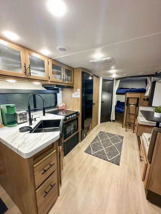 Spacious RV rental interior featuring a modern kitchen, cozy bunk beds, and a functional dining area.. Forest River Grey Wolf 26 DBH 2025