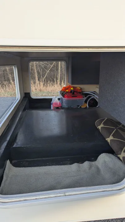 RV rental exterior storage: organized compartment with camping supplies, hoses, and a floor mat.. Forest River Coachmen Freelander 2013