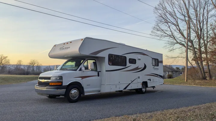 White Coachmen Freelander Class C RV rental parked on an asphalt road. Perfect for your next scenic road trip adventure.. Forest River Coachmen Freelander 2013