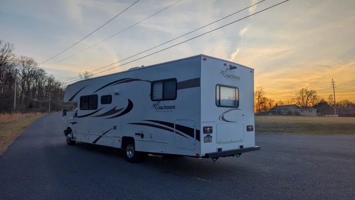 A white Coachmen Freelander RV rental, parked on a quiet road during a golden sunset. Perfect for your next outdoor adventure.. Forest River Coachmen Freelander 2013