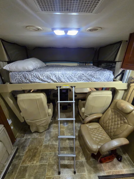 Inside this rv rental: an elevated bed, sturdy ladder, and two swiveling front seats for comfort.. Thor Motor Coach Miramar 2014