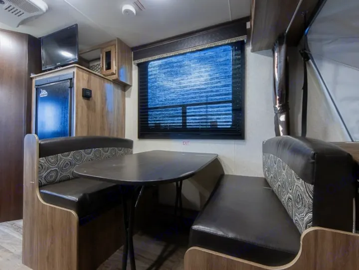 Explore this RV rental's comfortable dinette, fridge, and TV area. Perfect for meals & relaxation.. Jayco Jay Feather 2018