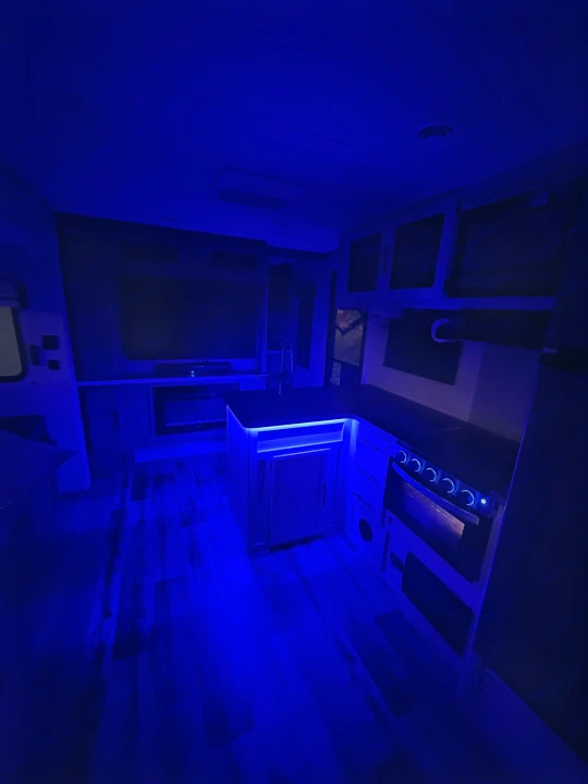 This RV rental features a sleek kitchen, comfy living area, and striking blue mood lighting.. Crossroads RV Volante 2023