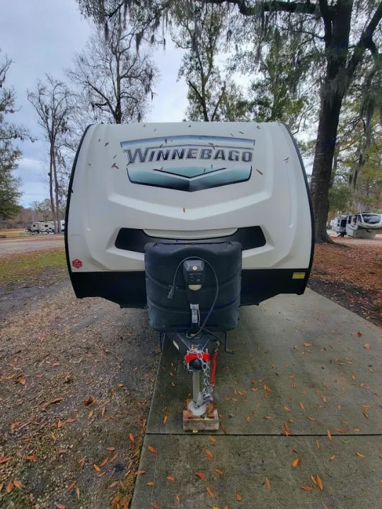 A white Winnebago travel trailer, ideal for an RV rental, is parked at a campsite. Front view showing hitch.. Winnebego Minnie Winnie 2020