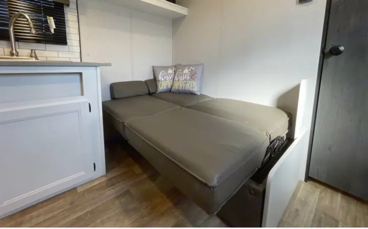 RV rental: Cozy interior featuring a convertible sofa bed next to a kitchen counter with a sink.. Keystone RV Hideout 2023