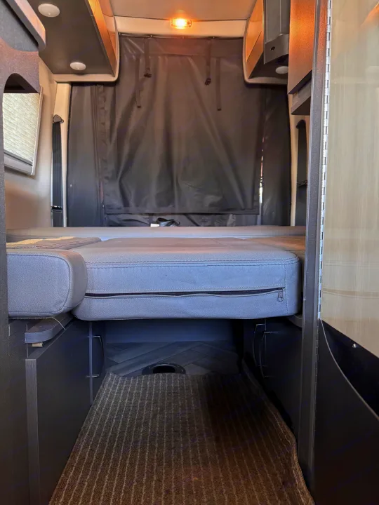 Experience comfort in this RV rental with its convertible bed, overhead storage, and rear privacy curtain.. Thor Sanctuary 2024