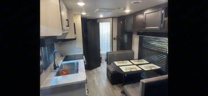 Explore this RV rental's inviting interior: functional kitchen, cozy dinette, and private bathroom for comfortable adventures.. Jayco Jay Flight SLX 2022