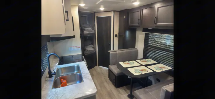 RV rental interior features kitchen, dinette, and bunk beds. Ideal for compact living and travel adventures.. Jayco Jay Flight SLX 2022
