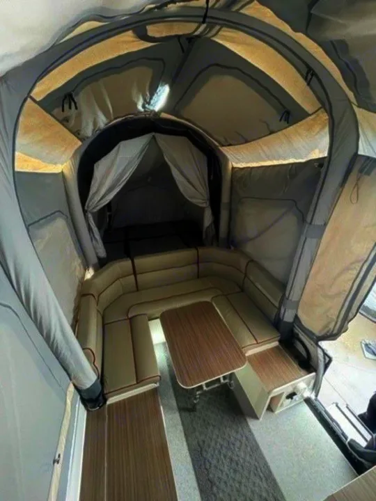 This rv rental features a spacious interior with a U-shaped dinette, central table, and an enclosed sleeping area.. Air Opus OP4 2021