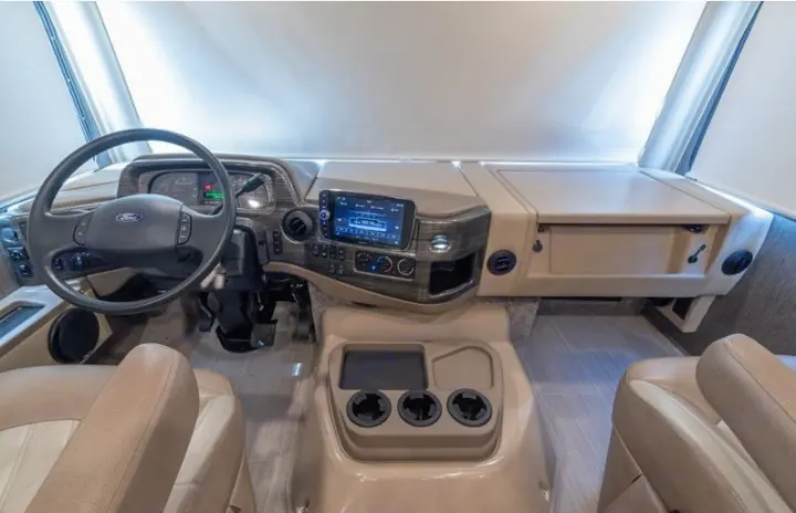 Explore this RV rental's spacious and modern cockpit. Features include the Ford steering wheel, infotainment, and comfy seats.. Thor Challenger 2021