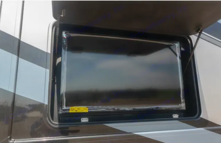 An RV rental's side compartment is open, revealing a large flat-screen TV for outdoor entertainment.. Thor Challenger 2021