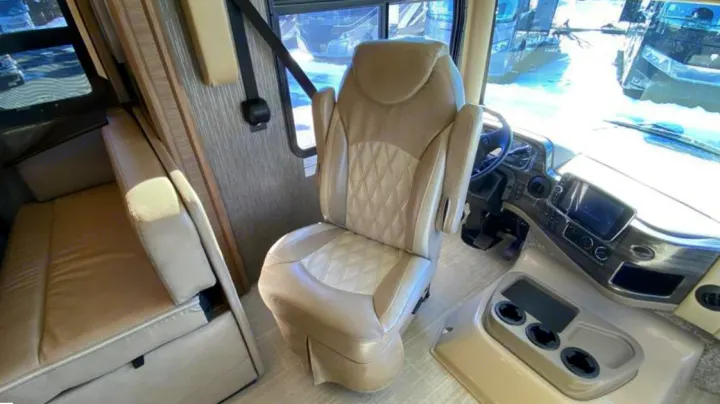 Spacious RV rental interior featuring the cockpit, comfortable driver's seat, and convertible sofa for a cozy journey.. Thor Challenger 2021