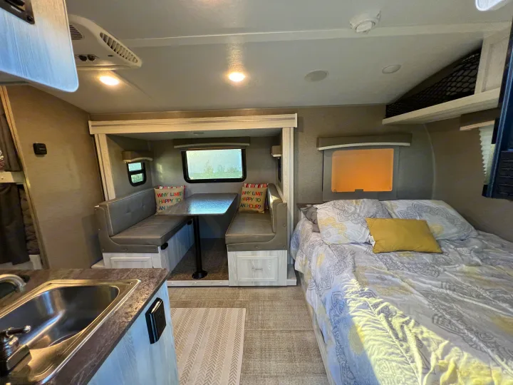 Spacious RV rental interior featuring a dinette, comfy bed, and kitchen sink. Perfect for your next adventure.. Forest River Rockwood Geo Pro 2020