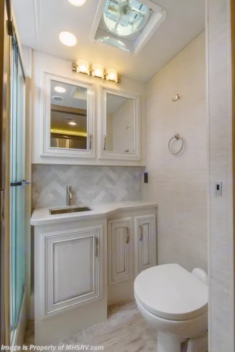 Modern RV rental bathroom: vanity, sink, toilet, shower, and bright lighting. Clean, functional, and compact design.. Entegra Coach Accolade 2023