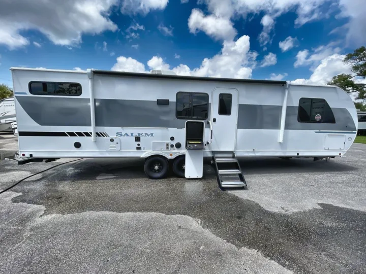 Explore in style! This white & gray Salem travel trailer RV rental features an outdoor grill and steps.. Forest River Salem 2025