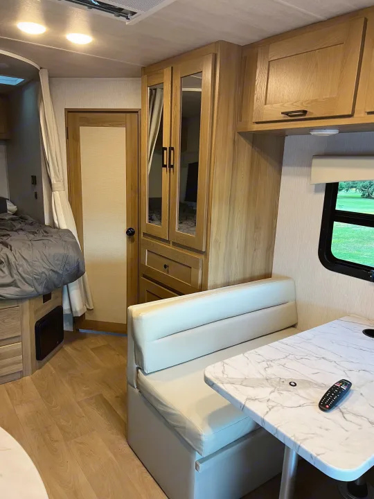 RV rental interior showcasing a cozy bed, dinette, and ample storage, perfect for travel comfort.. Nexus Phantom 2025