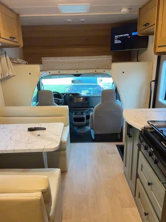 Experience this RV rental's spacious interior: dining area, kitchen, and comfy seating. TV shows system update.. Nexus Phantom 2025